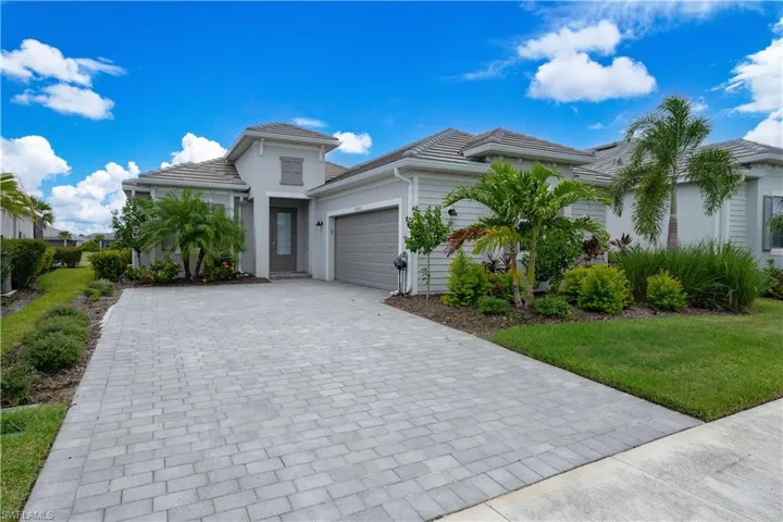 View of front facade featuring a garage and a front lawn