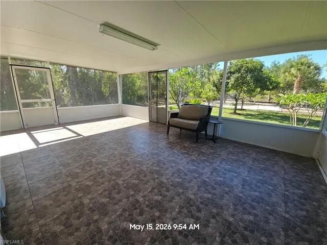 Expansive screened lanai featuring patterned tile flooring, a white ceiling with recessed lighting, and multiple screened entryways