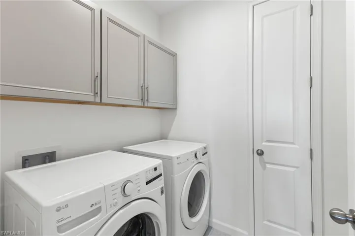 Laundry area featuring washing machine and clothes dryer and cabinet space