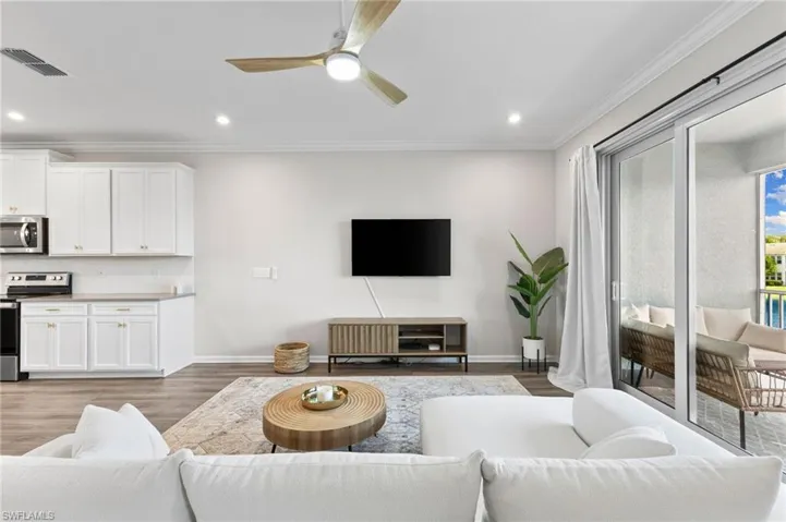 Living room with crown molding, light wood-style flooring, recessed lighting, and ceiling fan