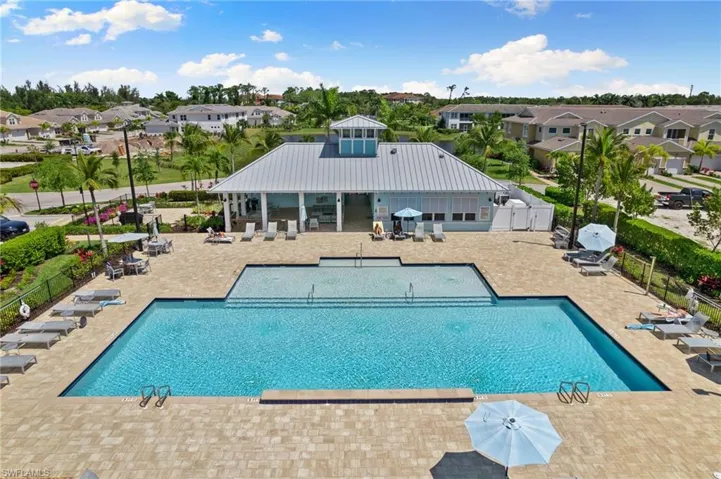 Community pool featuring a patio, a residential view, and a grill