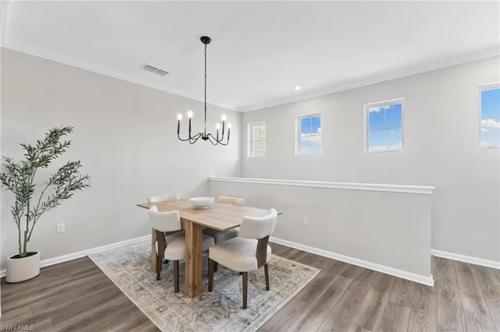 Dining room with crown molding, light wood-style flooring, a chandelier, and recessed lighting