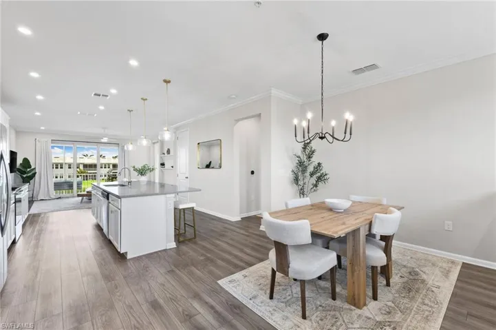 Dining area featuring recessed lighting, crown molding, dark wood finished floors, and a chandelier