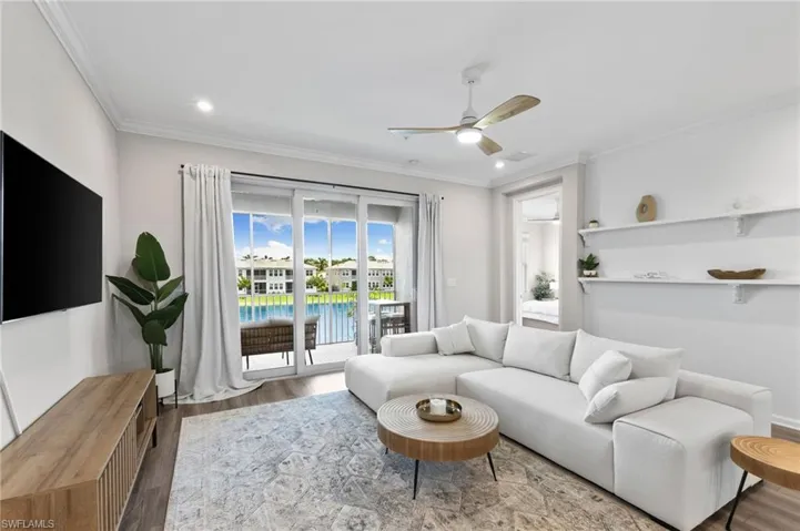 Living room with ornamental molding, wood finished floors, ceiling fan, a water view, and recessed lighting