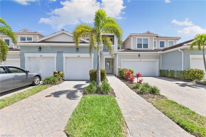 Traditional-style house featuring decorative driveway, stucco siding, and a garage