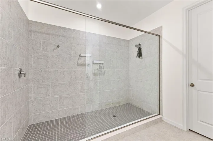 Full bath with a shower stall, tile patterned flooring, and recessed lighting