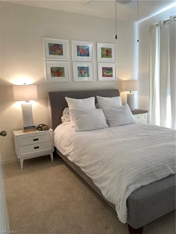 Carpeted guest  bedroom featuring a ceiling fan