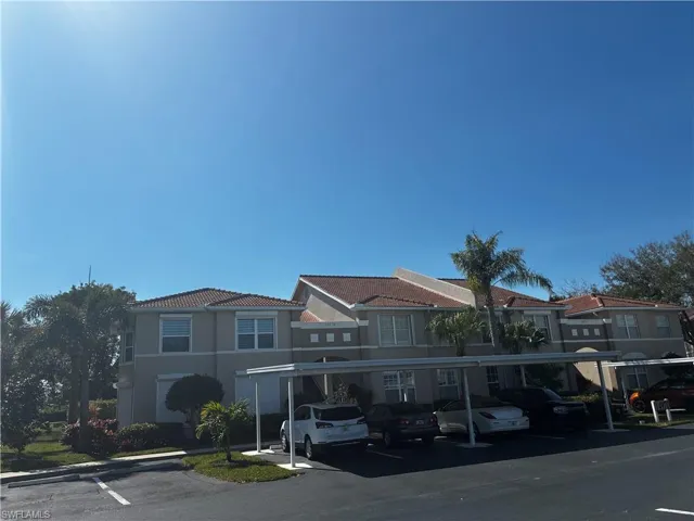 View of building exterior with covered parking