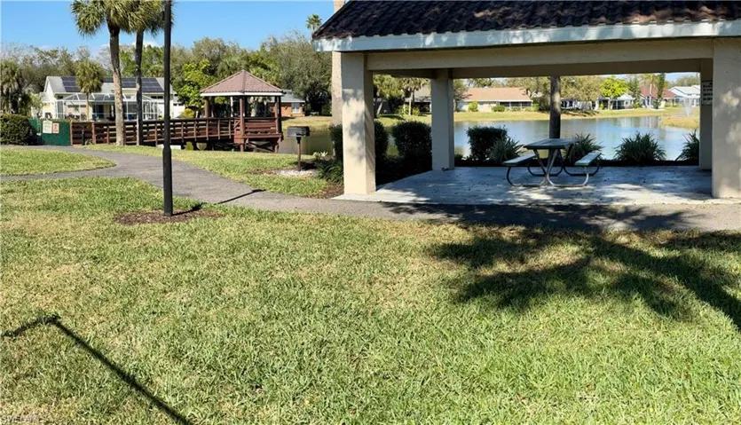 View of grassy yard with a gazebo area, and a water view at the community park
