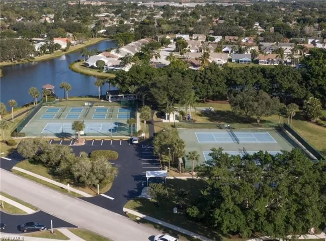 View of property location with one of the 9 lakes at the park featuring fishing pier, playground and tennis pickleball courts