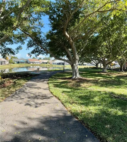 View of walking path thru park  with a residential view and a water view
