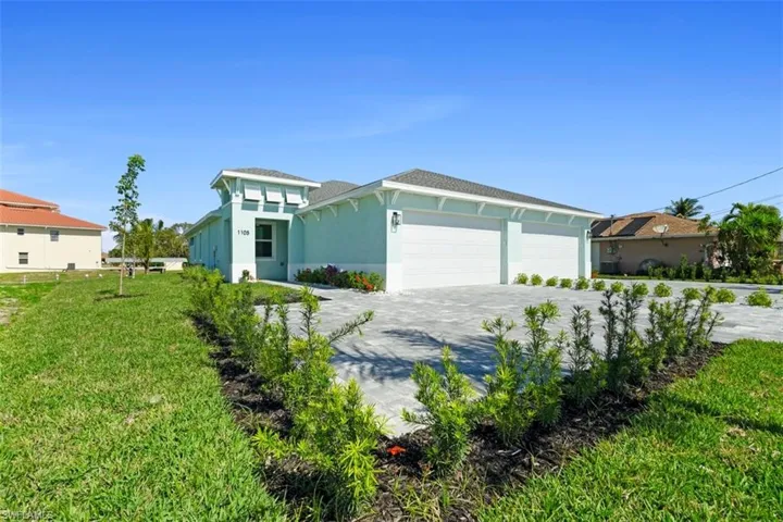 View of front of home featuring a garage, decorative driveway, a front yard, and stucco siding