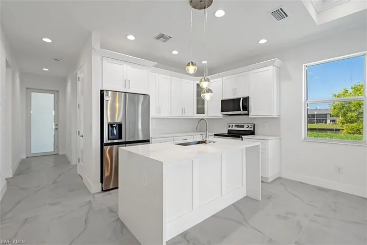 Kitchen with a sink, recessed lighting, marble finish floor, and stainless steel appliances