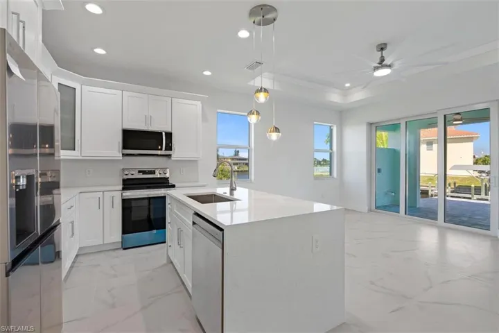 Kitchen with a sink, visible vents, marble finish floor, and stainless steel appliances