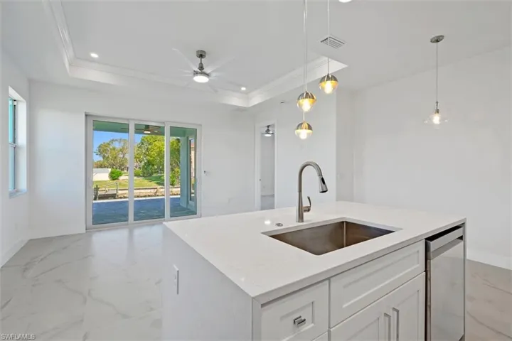 Kitchen featuring visible vents, dishwasher, a raised ceiling, and a sink