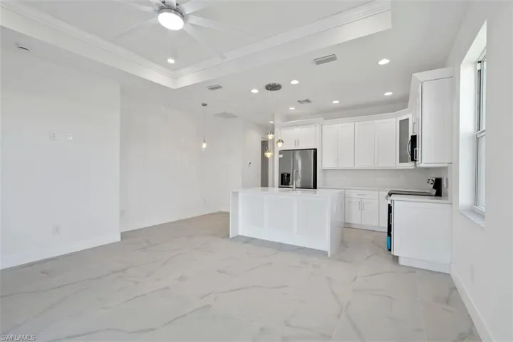 Kitchen with a ceiling fan, baseboards, recessed lighting, stainless steel appliances, and marble finish floor