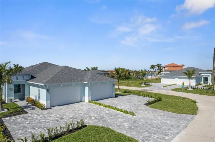 Ranch-style house featuring roof with shingles, decorative driveway, an attached garage, and stucco siding