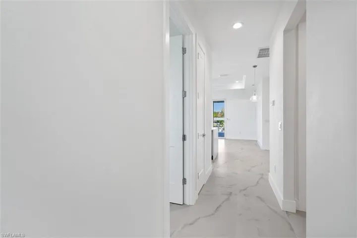 Hall with recessed lighting, marble finish floor, visible vents, and baseboards