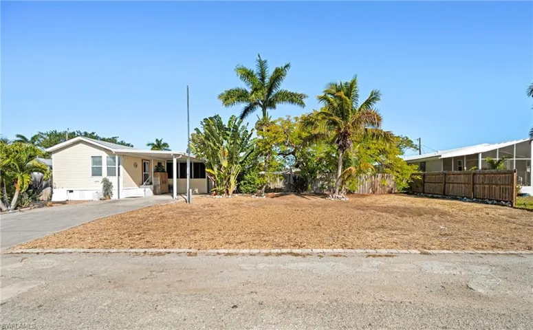 Manufactured / mobile home featuring concrete driveway and a carport