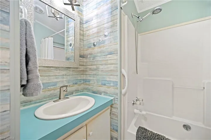 Full bathroom with shower / tub combo with curtain, vanity, and crown molding
