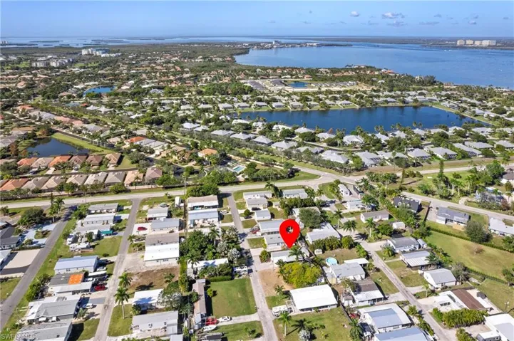 Aerial view of property and surrounding area featuring nearby suburban area and a nearby body of water