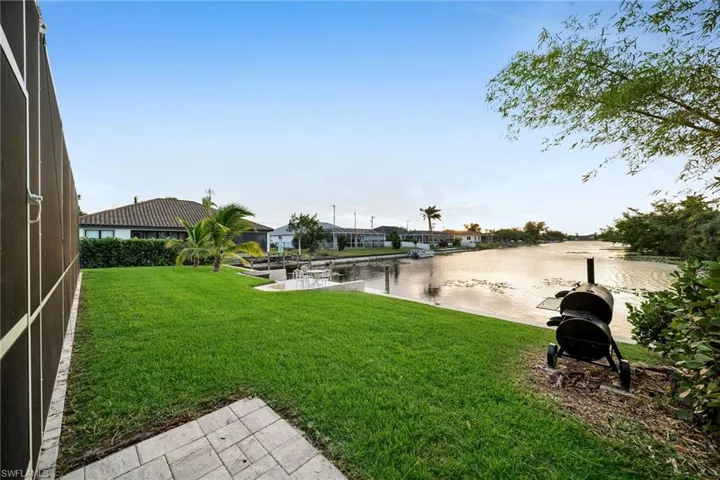 View of yard with a boat dock and a water view