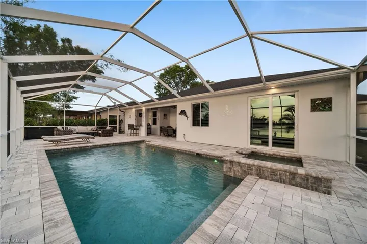 View of pool featuring a lanai, a patio area, and an outdoor living space
