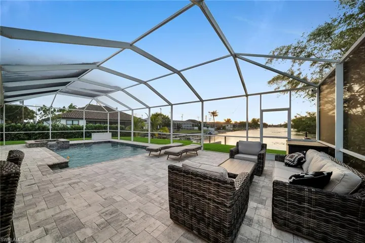View of swimming pool with an outdoor living space, a patio area, and a lanai