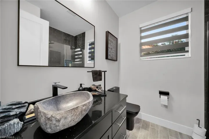 Bathroom featuring wood-type flooring, vanity, toilet, and a shower with shower door
