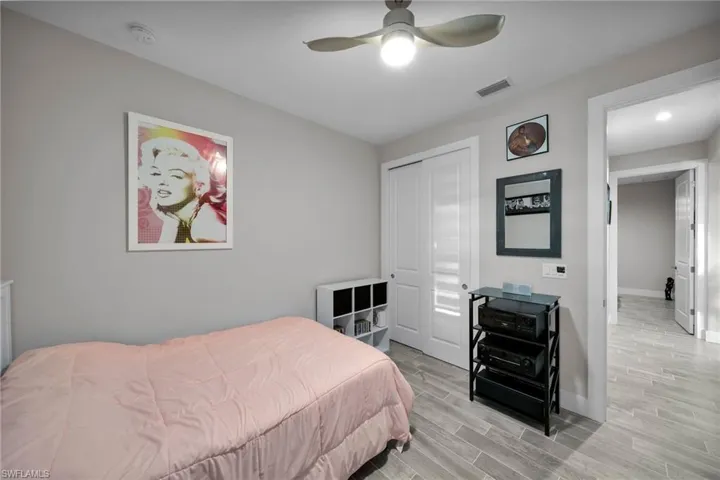Bedroom with ceiling fan, a closet, and light hardwood / wood-style floors