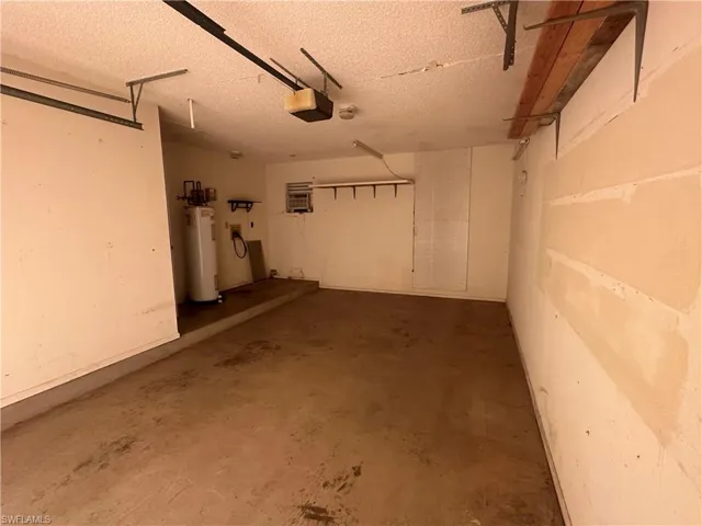 Garage featuring water heater and a garage door opener