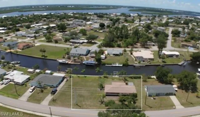 Aerial perspective of suburban area featuring a nearby body of water and property boundaries highlighted