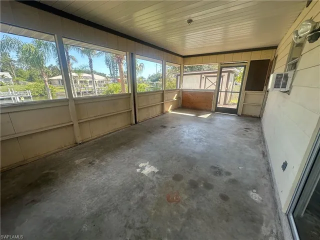 Unfurnished sunroom with plenty of natural light and cooling unit