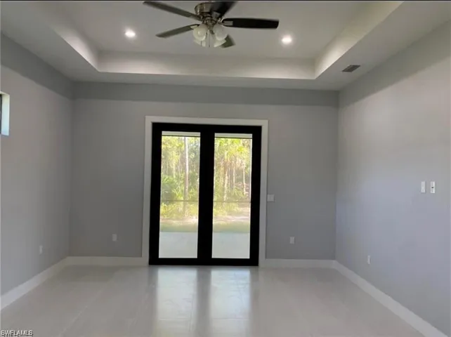 Unfurnished room with a ceiling fan, a raised ceiling, and recessed lighting