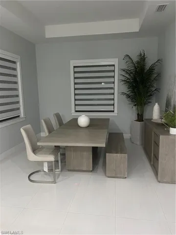 Dining room featuring a raised ceiling and light tile patterned floors