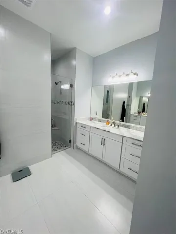 Bathroom featuring a shower stall and vanity