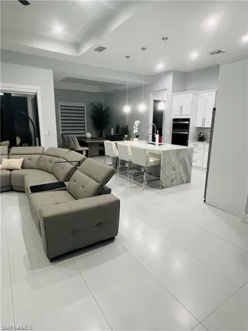 Living room with recessed lighting and light tile patterned floors