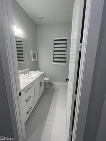 Half bathroom featuring vanity and light tile patterned floors
