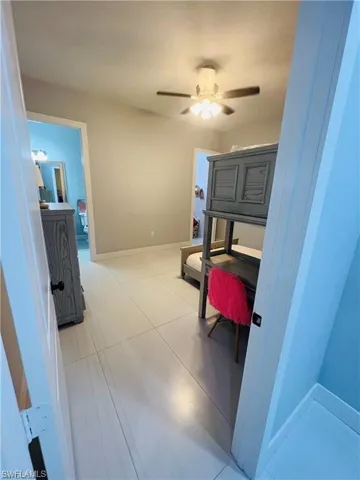 Hallway featuring a desk and light tile patterned floors