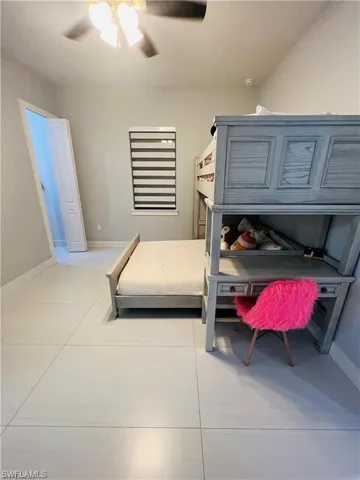 Bedroom with a ceiling fan and light tile patterned floors