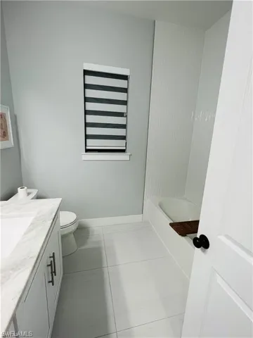 Bathroom with vanity, light tile patterned floors, and tub / shower combination