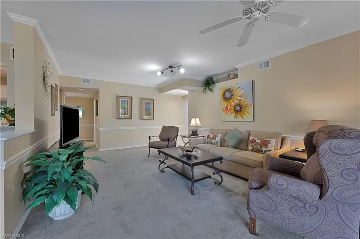 Living room featuring crown molding, ceiling fan