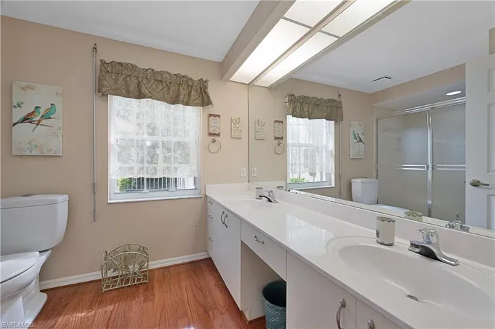 Bathroom featuring plenty of natural light, a shower with door, and vanity