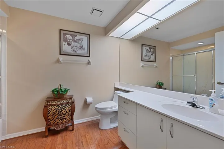 Bathroom featuring vanity, wood flooring, an enclosed shower