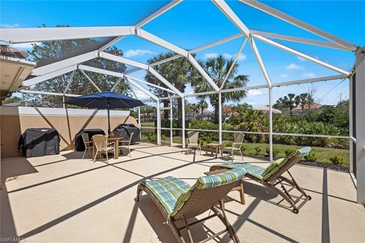 View of patio featuring glass enclosure and grilling area