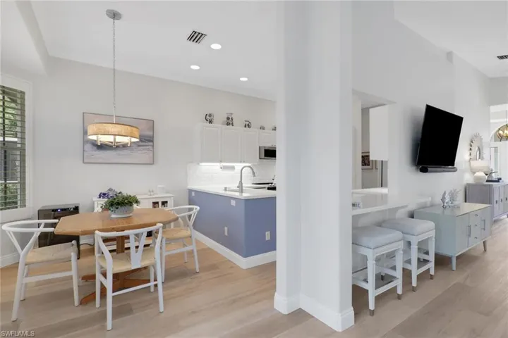 Dining room featuring light wood-style flooring, crown molding, and recessed lighting
