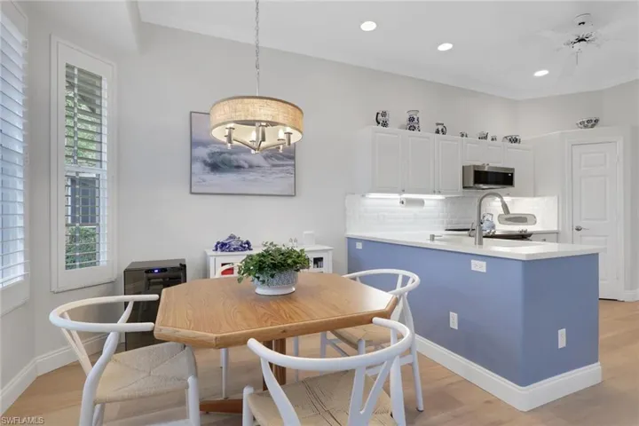 Dining area with light wood-style floors, crown molding, ceiling fan, and a chandelier