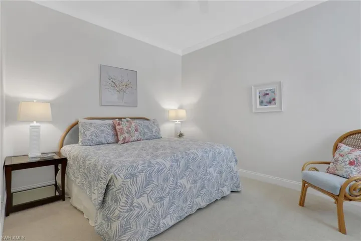 Bedroom with crown molding, light carpet, and a ceiling fan