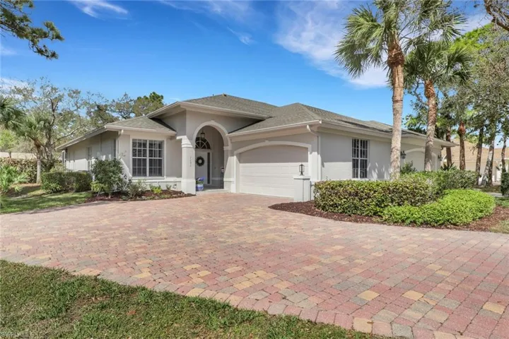 Single story home with a garage, stucco siding, and decorative driveway