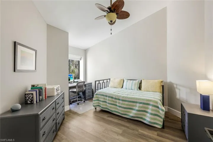 Bedroom with  wood-style flooring, a desk, and a ceiling fan